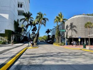 a city street with palm trees and a building