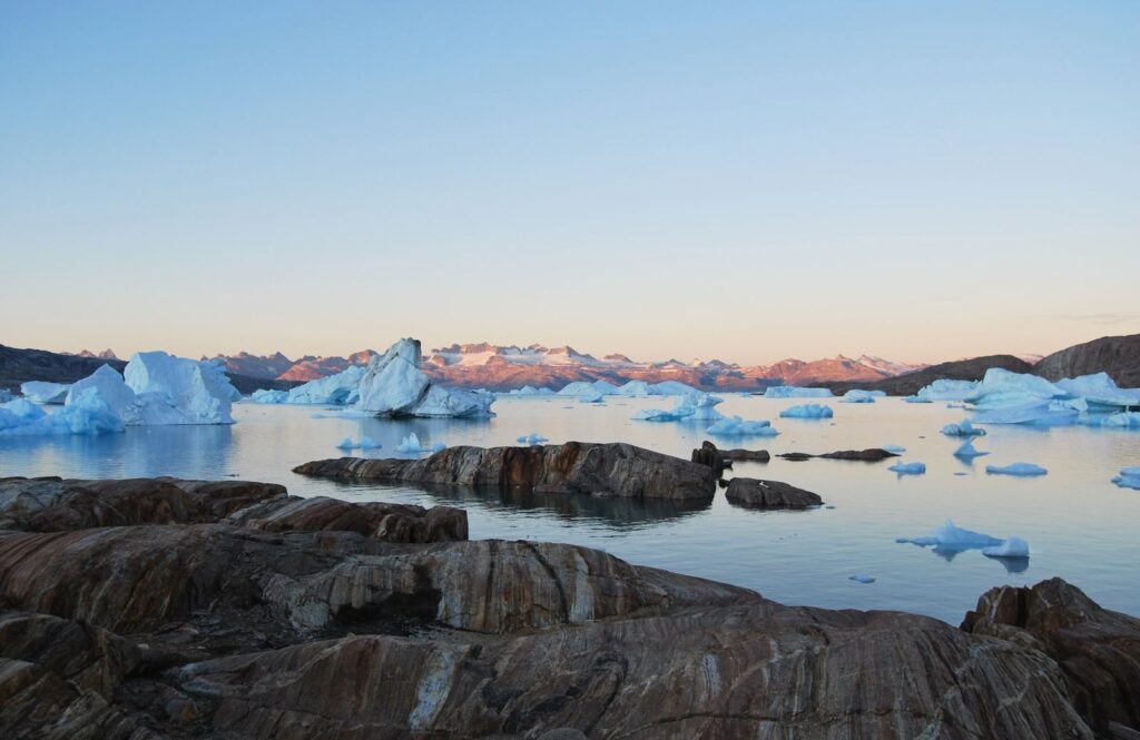 Stunning icebergs float peacefully in a serene Greenland landscape at dawn.
